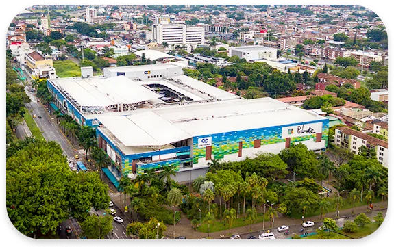 Vista aérea de Palmetto Plaza en Cali, con su fachada de colores y árboles alrededor.